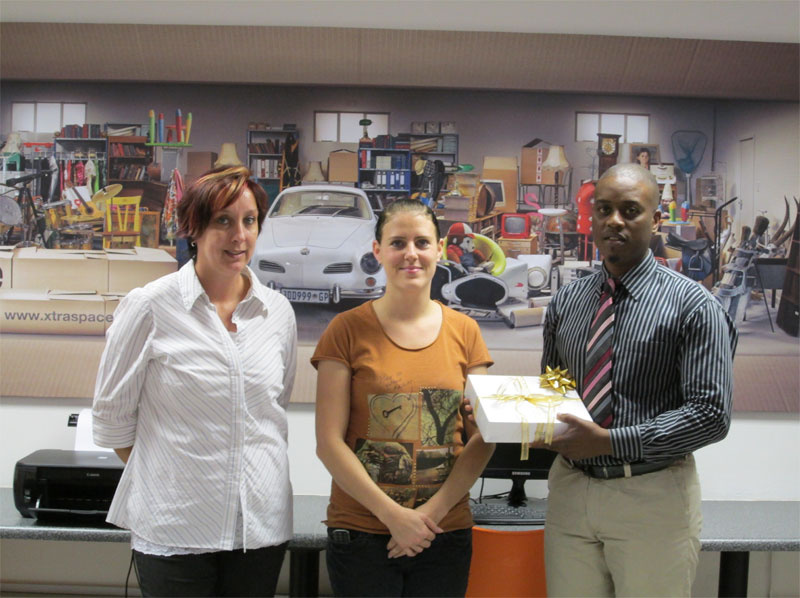 XtraSpace staff handing over iPad prize to Karen Chapman